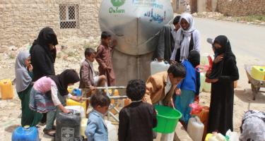 Frauen und Kinder holen Wasser an einem Tank in Khamir im Jemen. Frauen und Kinder holen Wasser an einem Tank in Khamir im Jemen.