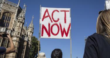 Ein Klimaschild "Act Now" auf einem Klimaprotest in London Ein Klimaschild "Act Now" auf einem Klimaprotest in London
