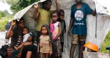 Maria mit ihren sechs Kindern sucht Schutz vor dem Regen. Eine Familie in Mosambik muss vor den Fluten fliehen.