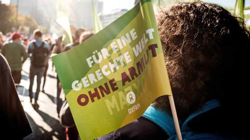 Eine Oxfam-Fahne ist auf einer Demonstration zu sehen