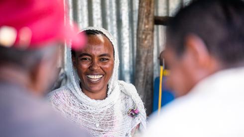 Eine Frau empfängt Kund*innen in ihrem Laden